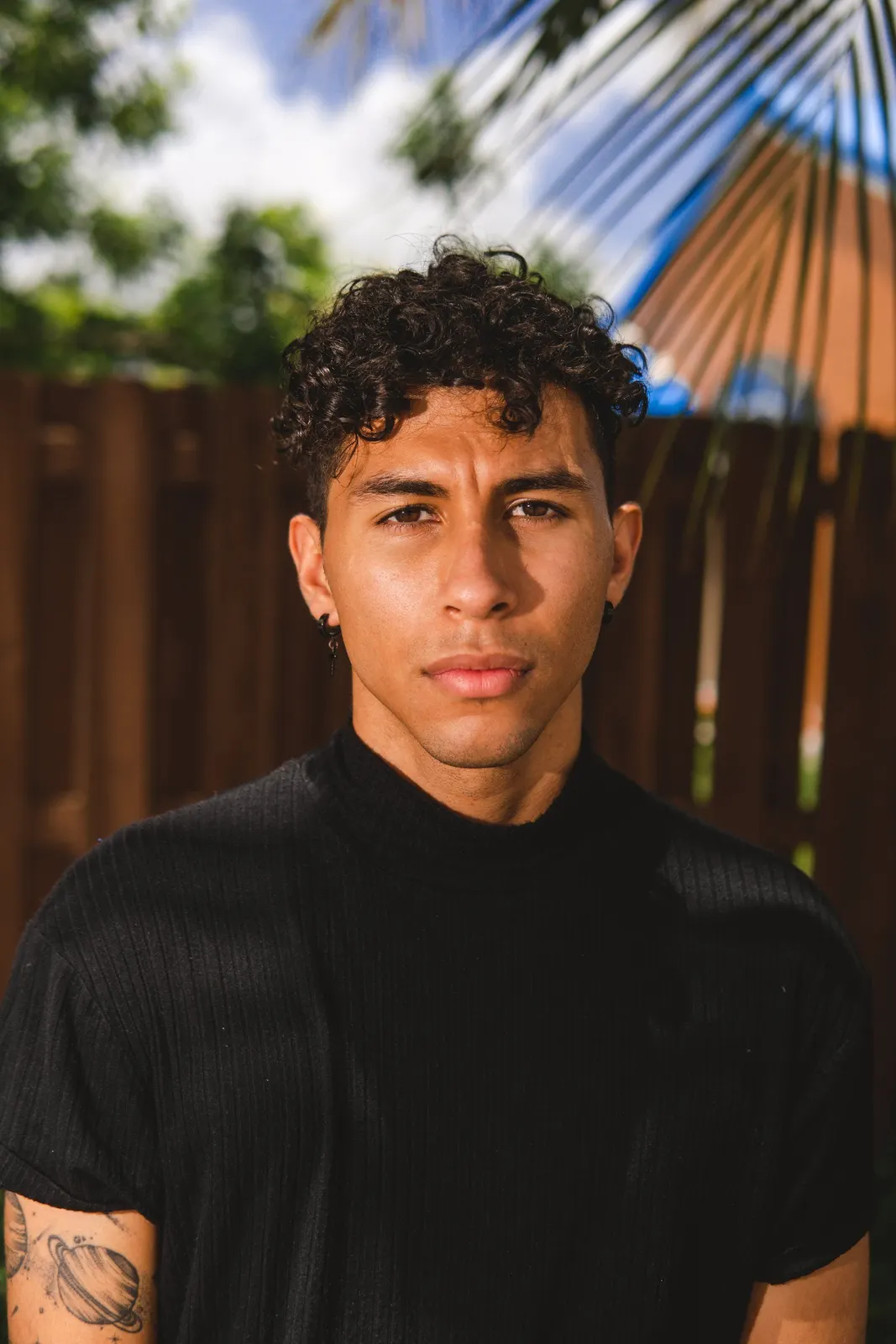 Young man in a black shirt standing outdoors